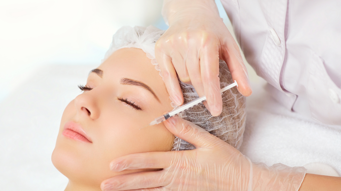 A woman is getting a botox injection in her face.