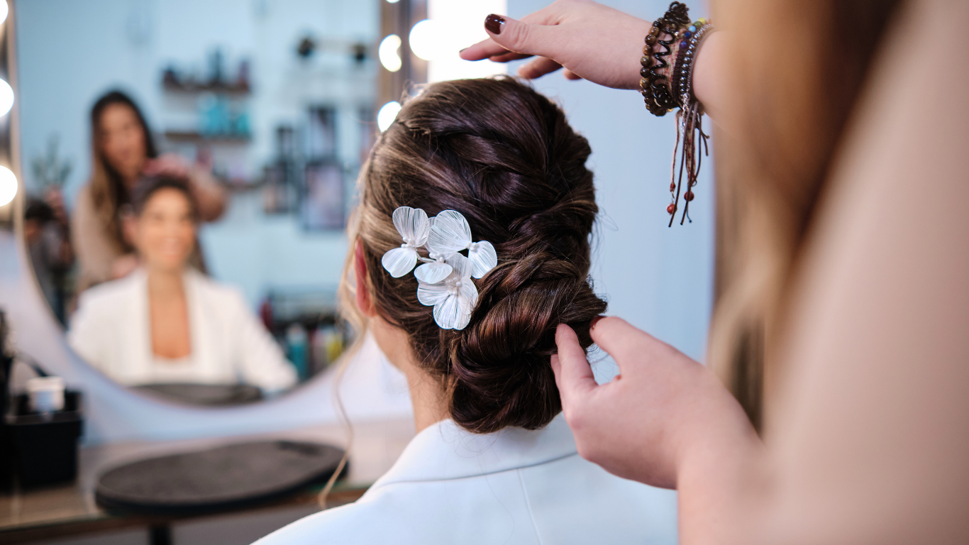 A woman is getting her hair done by a hairdresser in a salon.