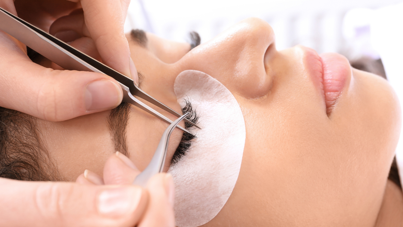 A woman is getting her eyelashes done at a beauty salon.