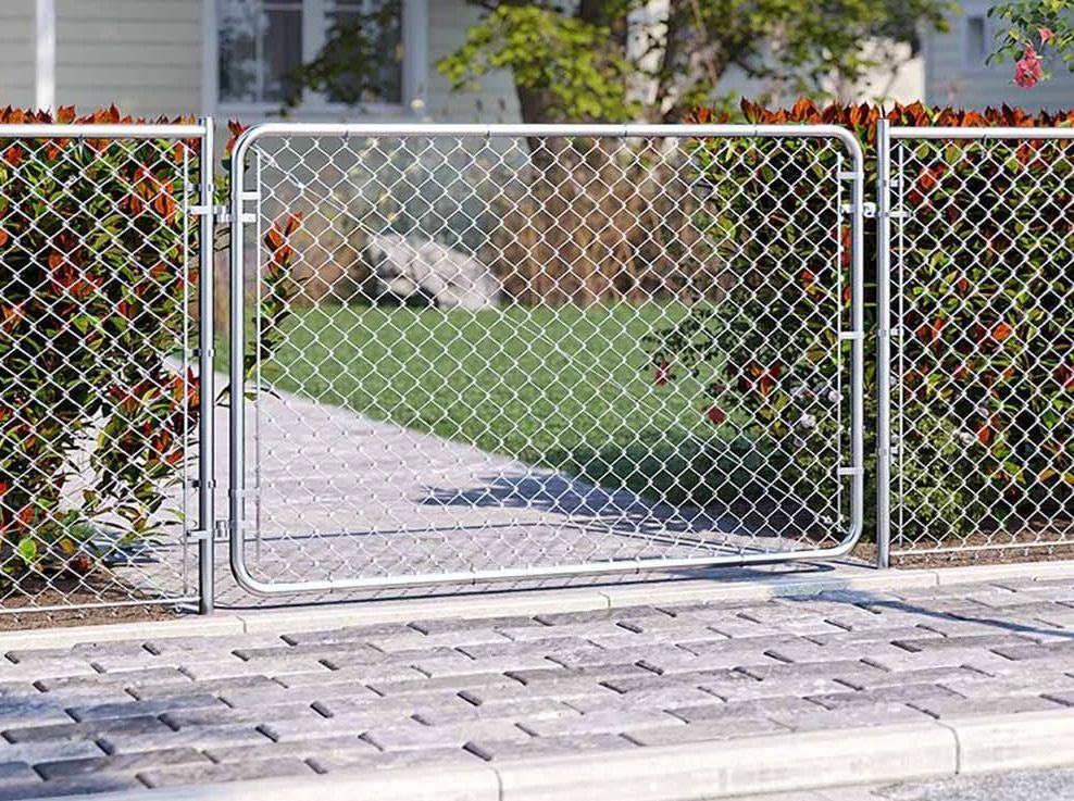 A chain link fence with a gate in front of a house.