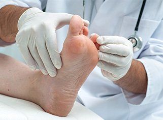 Routine Foot Care — Podiatrist Checking a Foot in Sterling Heights, MI