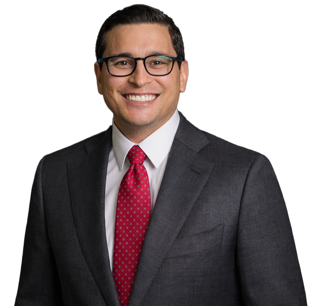 Man in a suit smiles, wearing glasses and a red tie.