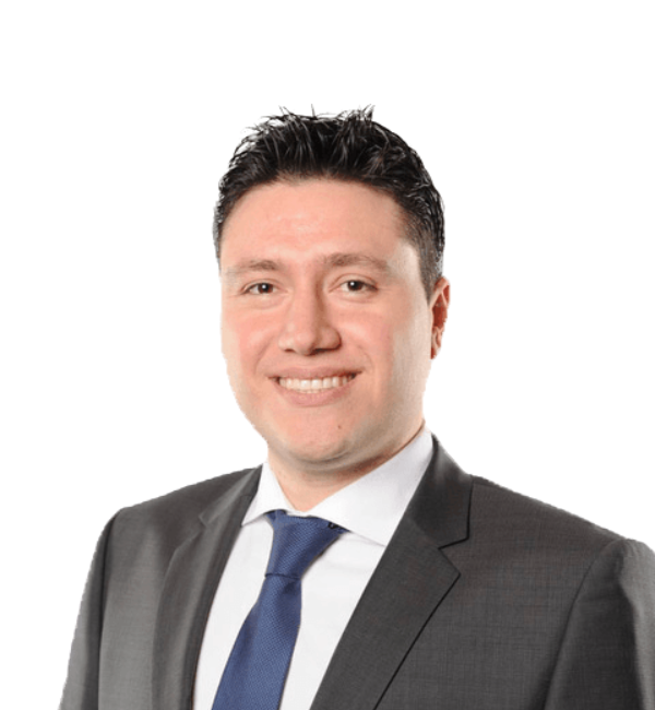 Man in a dark gray suit and blue tie smiling, on a white background.