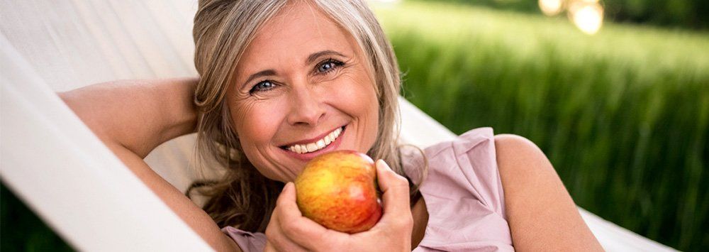 Older woman eating an apple