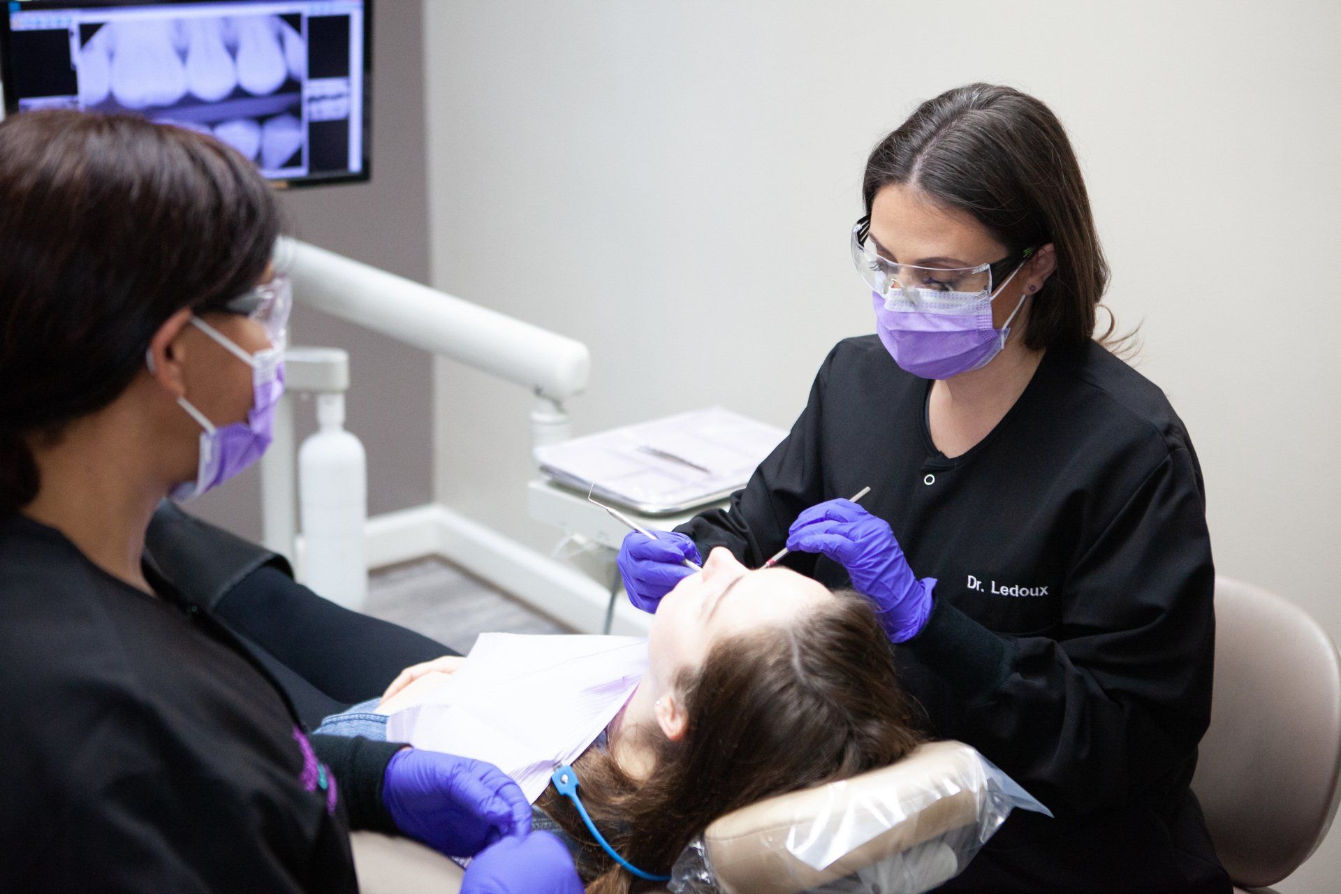 A woman is getting her teeth examined by a dentist in a dental office.