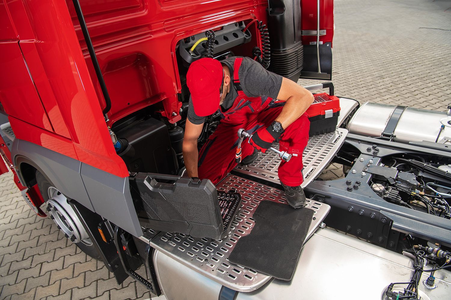 The mechanic carefully prepares tools, getting ready to begin essential truck repair work. The mechanic carefully prepares tools, getting ready to begin essential truck repair work.