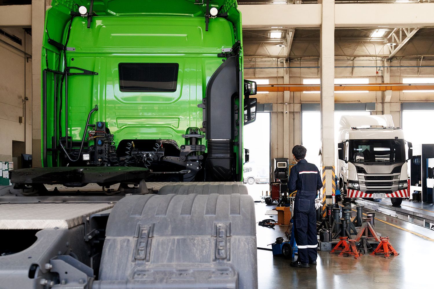 A technician working on trailer body repair in a truck service garage.