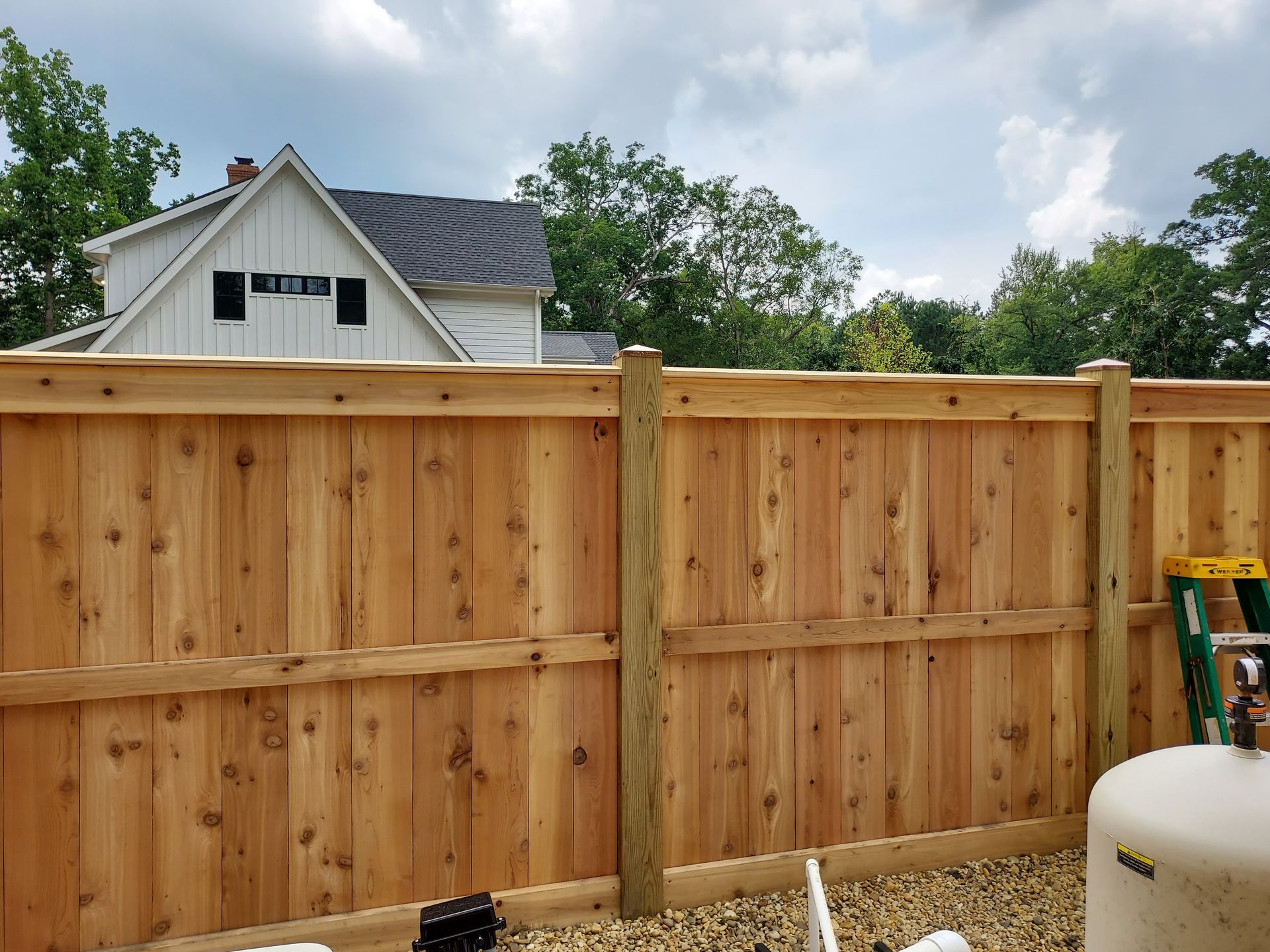 A wooden fence is being built in front of a house.