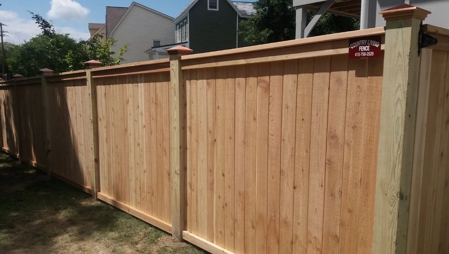 Wooden privacy fence in a yard, sunny day.