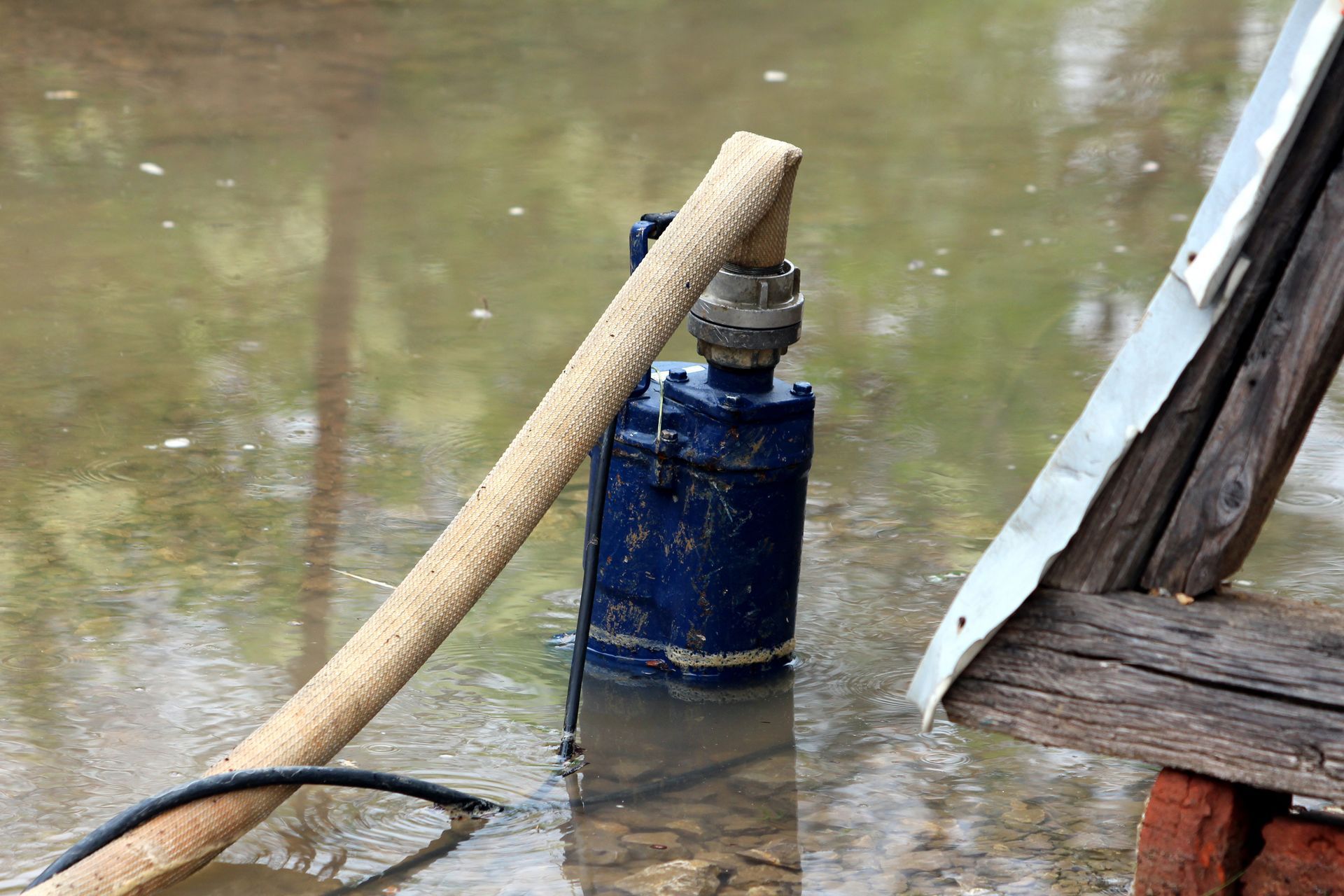Dark blue dilapidated old partially submerged metal water pump.