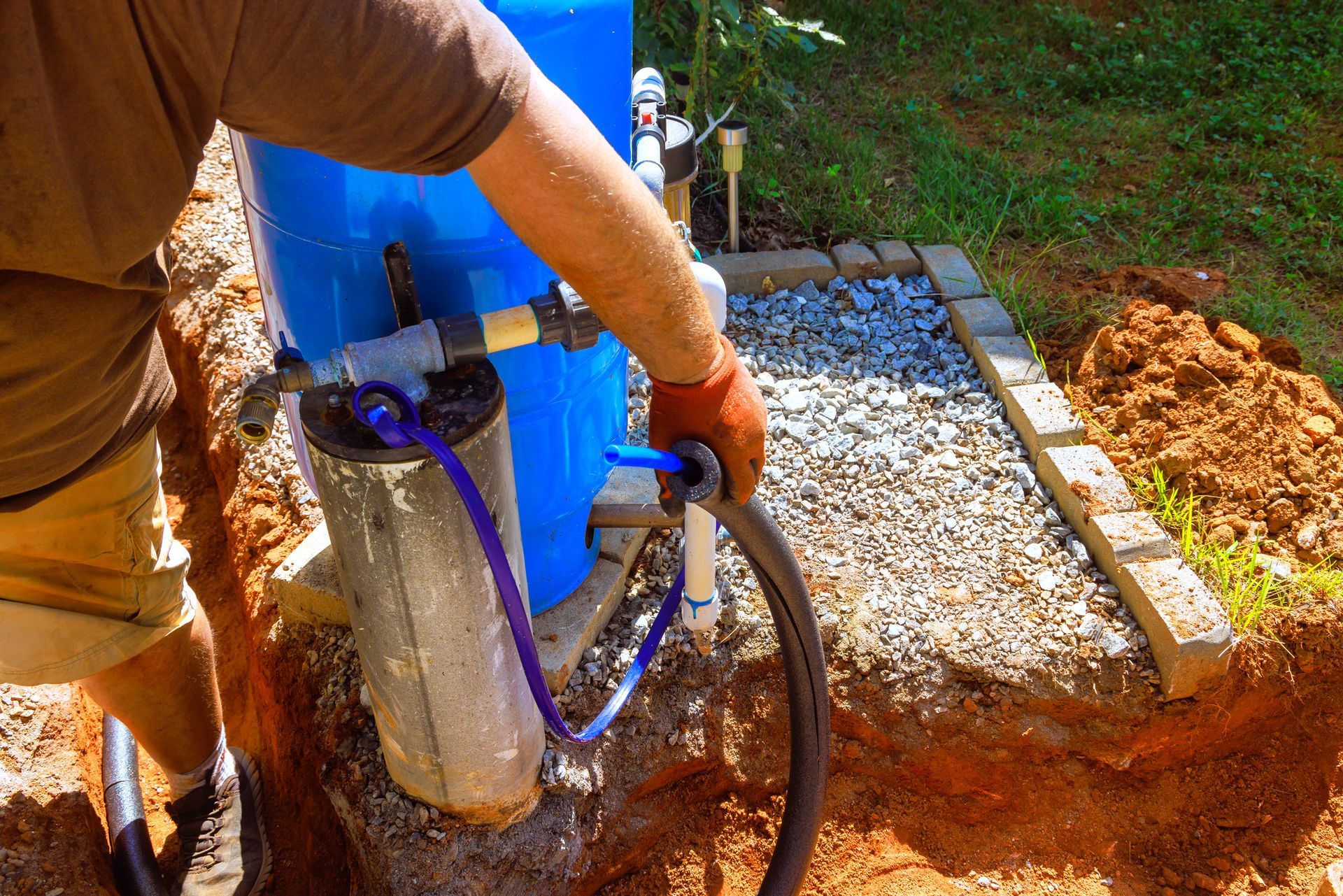 A plumber is connecting a submersible well pump.