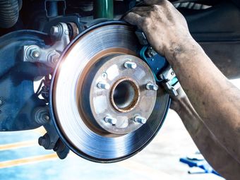 A person is fixing a brake disc on a car.