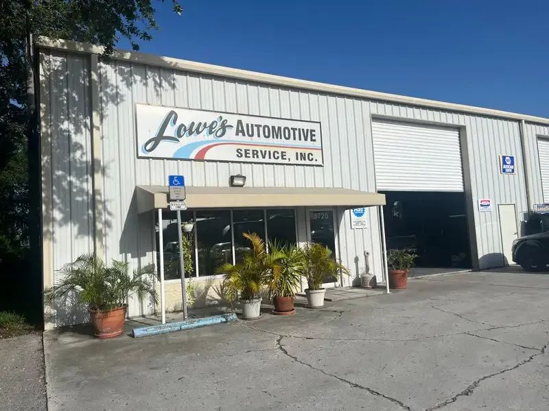 Lowe's Automotive Service, Inc. building with open garage door and awning over entrance.