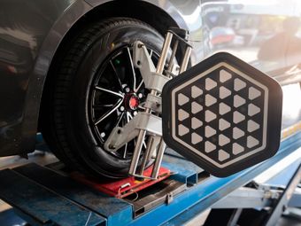 A car is being aligned with a machine in a garage.