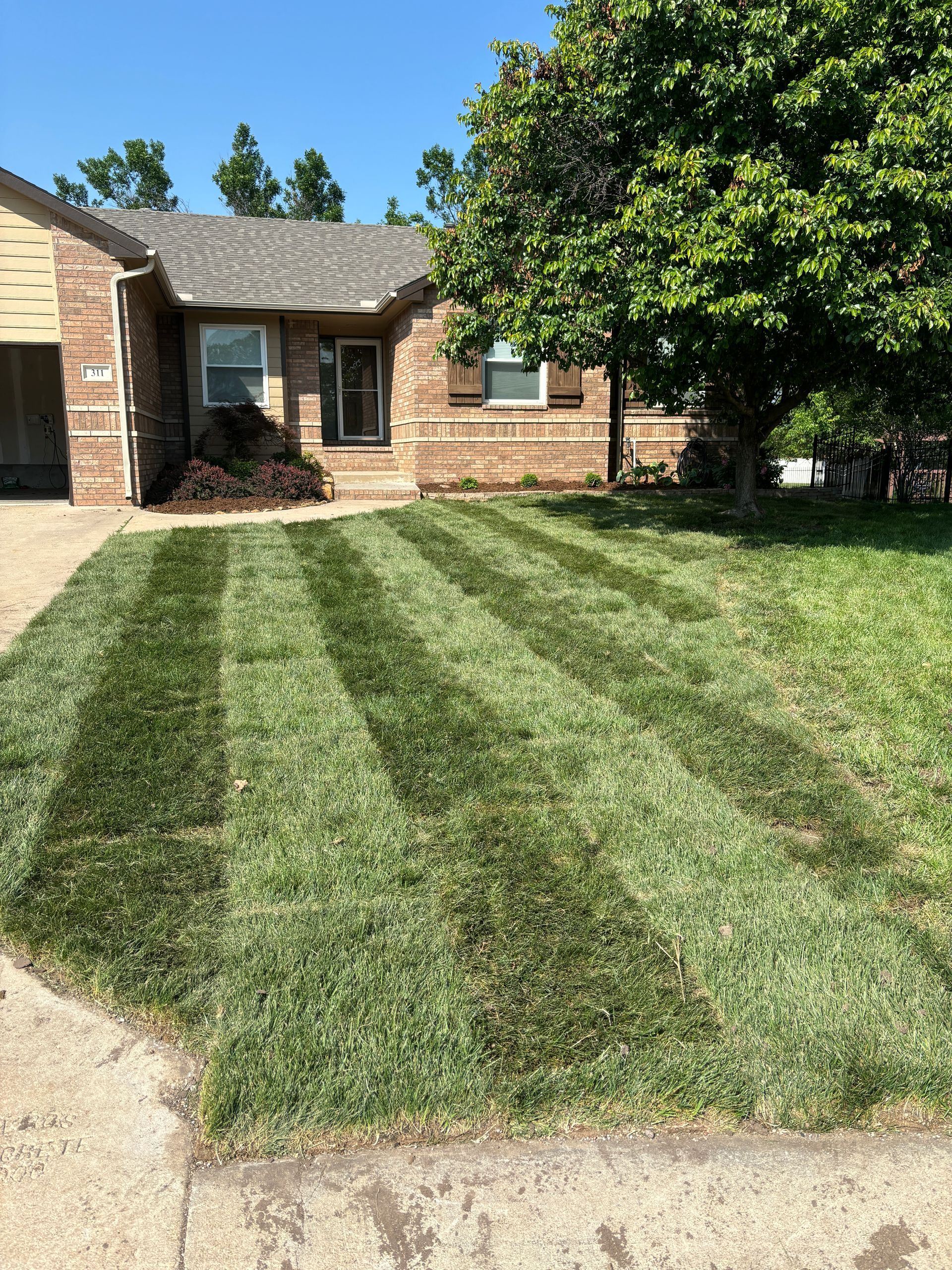 A house with a lush green lawn in front of it.