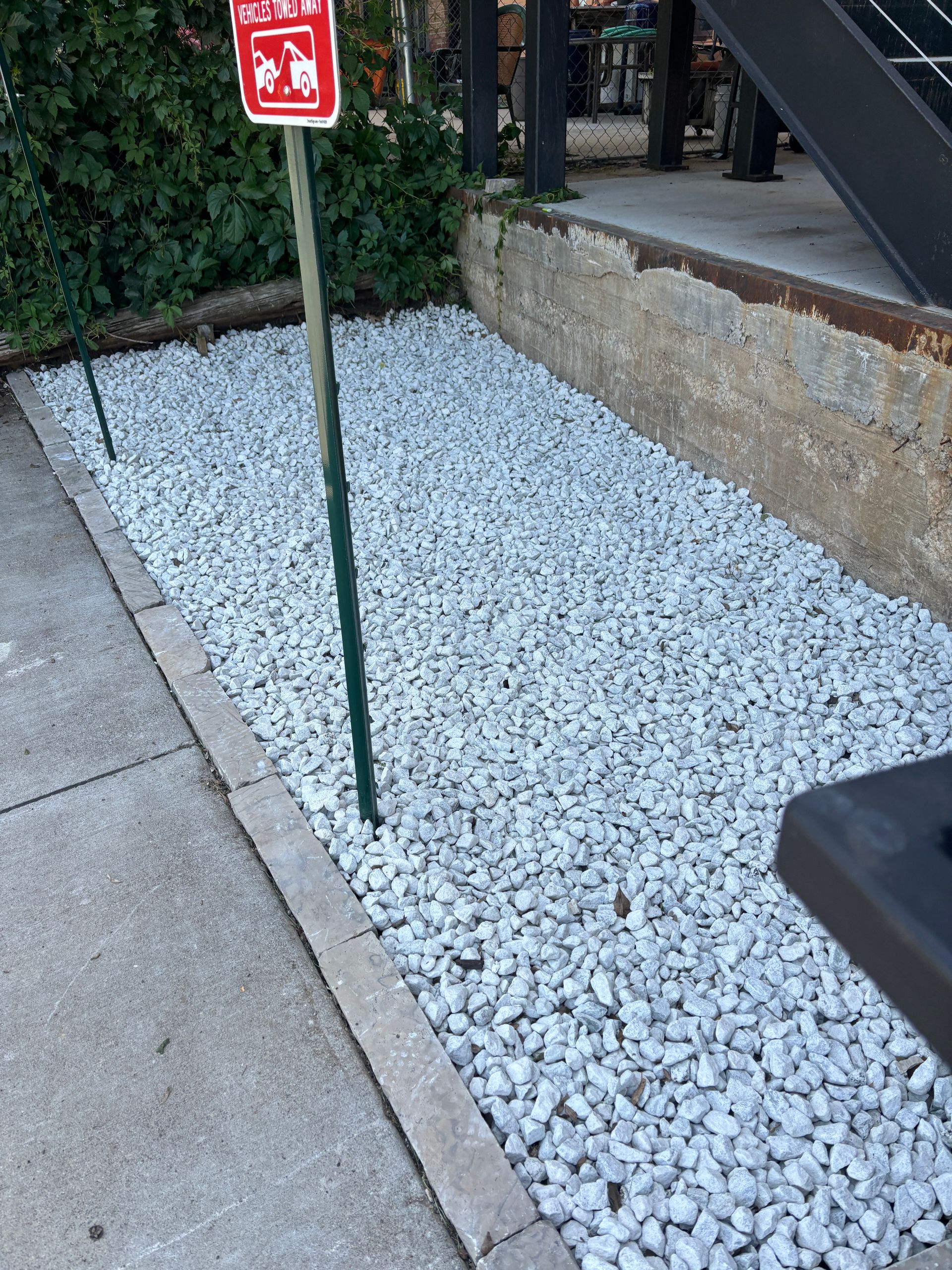 A pile of gravel next to a sign that says no parking