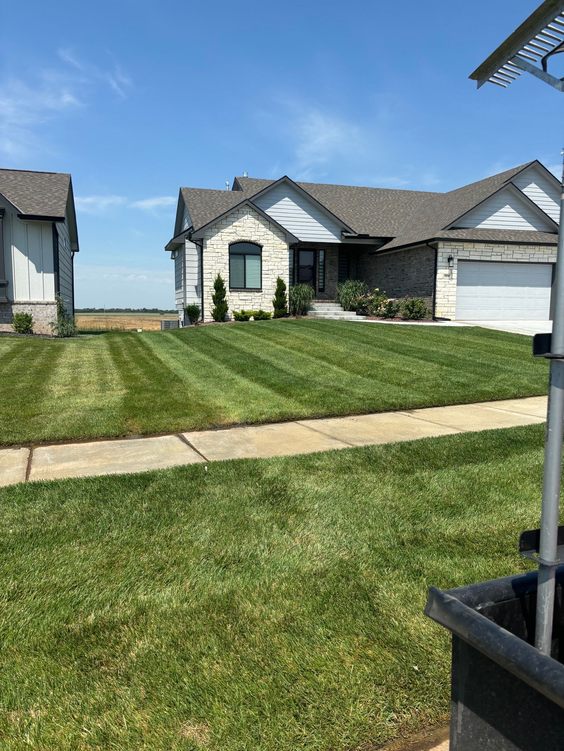 A house with a lush green lawn in front of it.