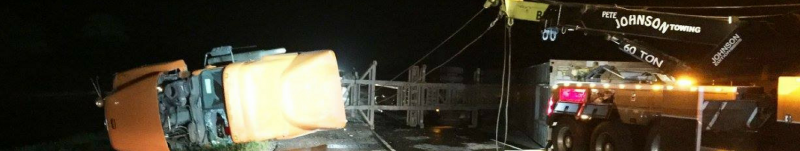 Orange vehicle and metal scaffolding at night. Dark environment, possibly a construction site.