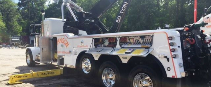 White tow truck with black crane and 