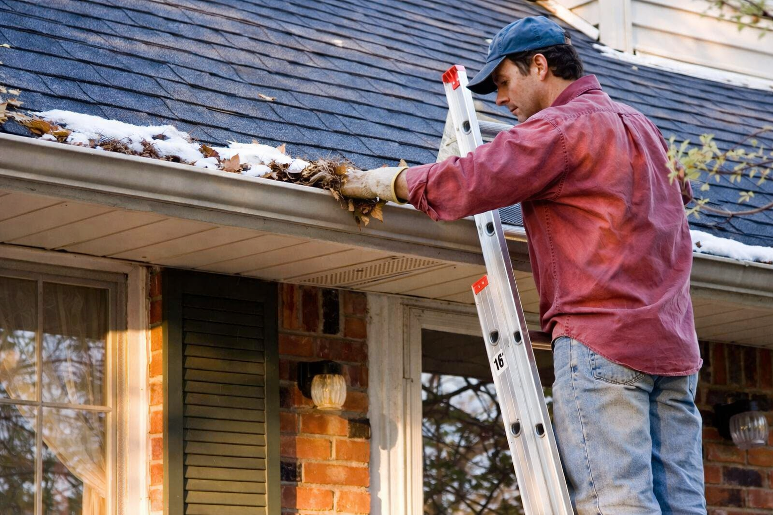 Cleaning residential gutters before winter to prevent ice dams on an Ogden Utah home