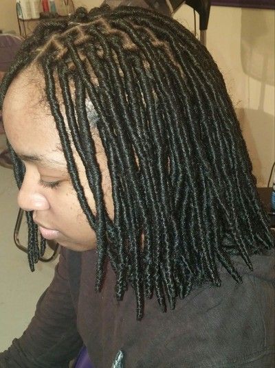 A woman with dreadlocks is wearing a black shirt.