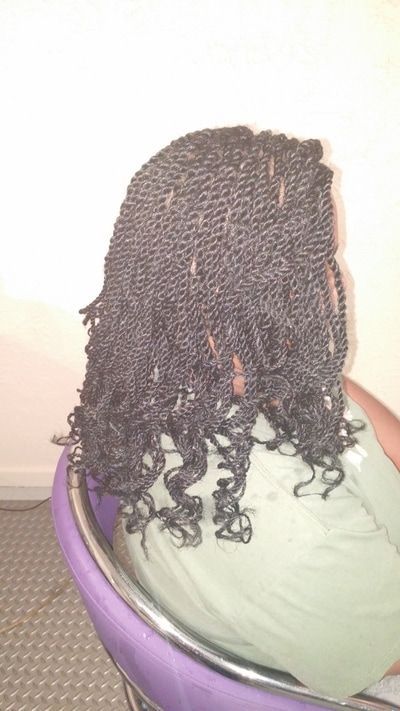 A woman with braids is sitting in a purple chair.