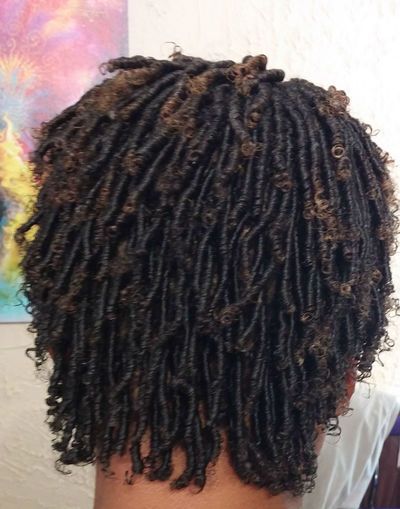 A close up of a person 's hair with dreadlocks