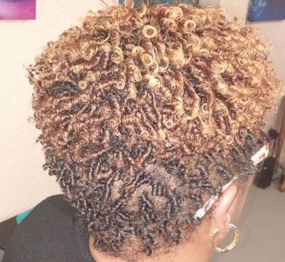 A woman with curly hair is wearing hoop earrings