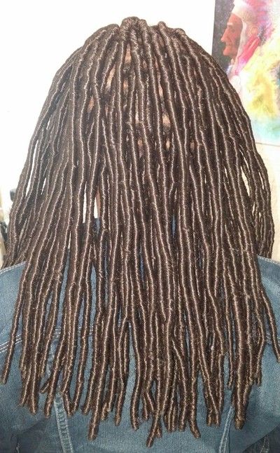 A close up of a person 's hair with dreadlocks.