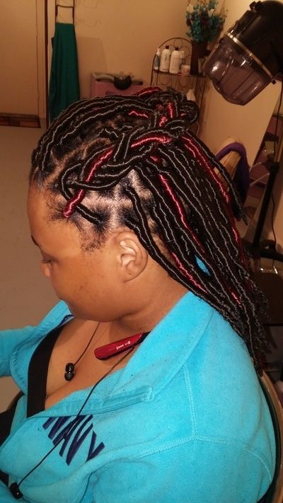 A woman with braids is wearing a blue shirt with the word navy on it.