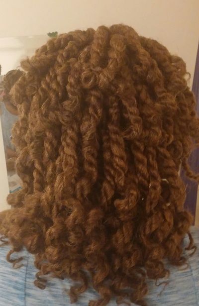 A close up of a person 's head with curly hair.