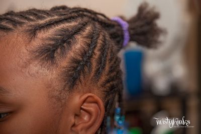 A close up of a child 's hair with braids and a ponytail.