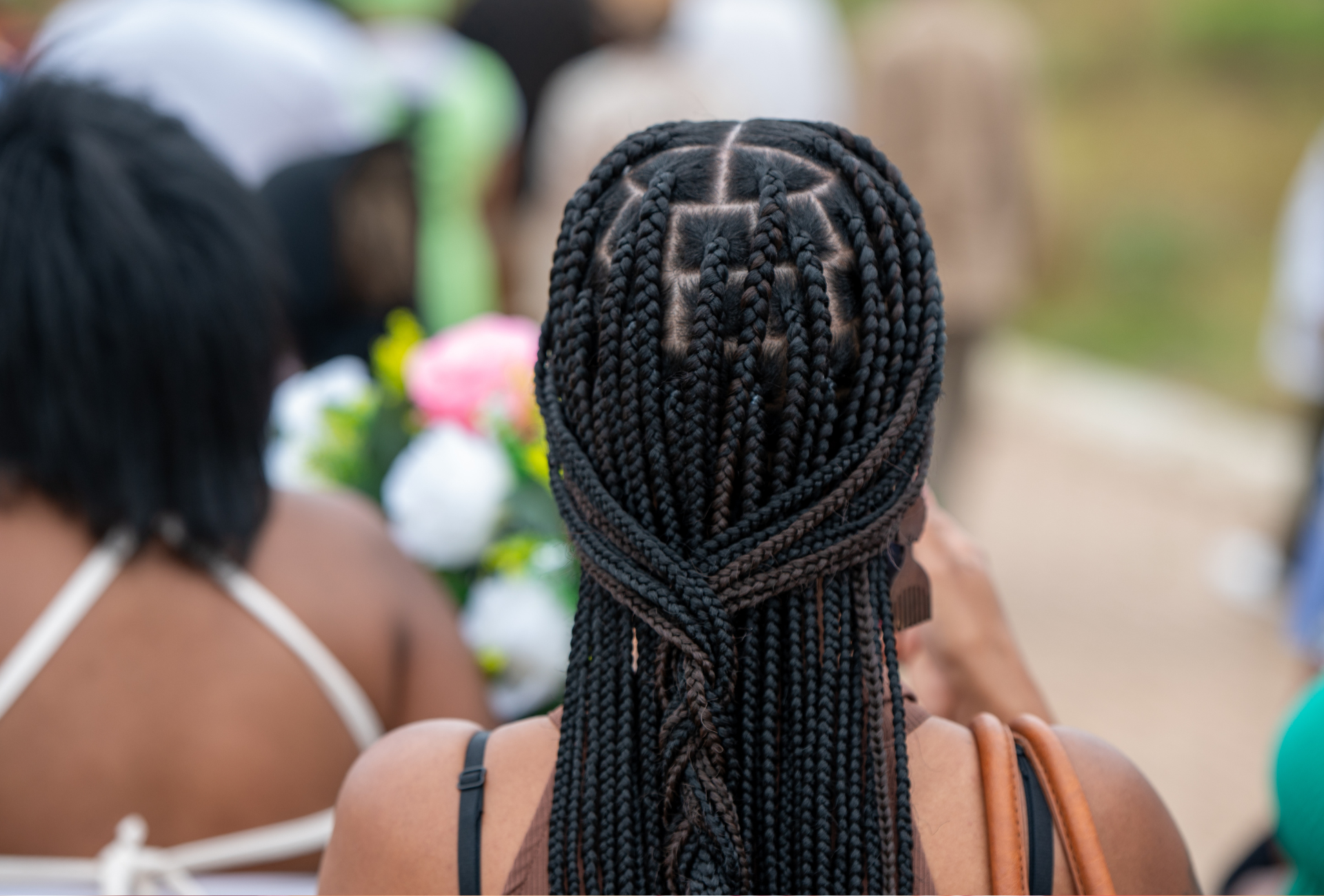 A woman with braids in her hair is standing in a crowd of people.