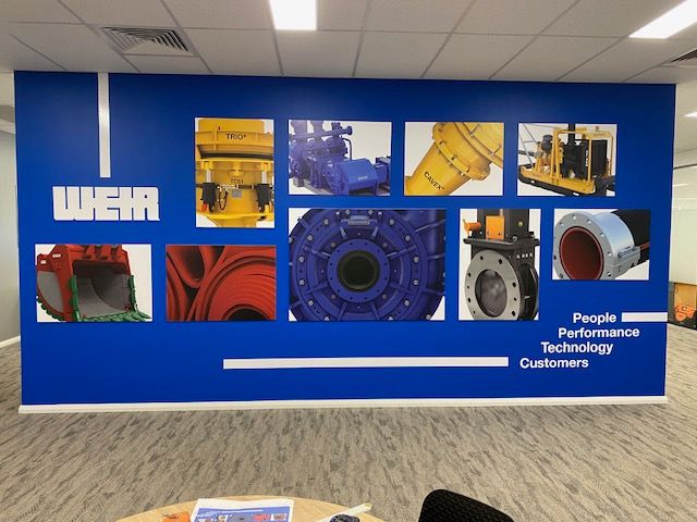 A wall with pictures of machinery and the word weir on it