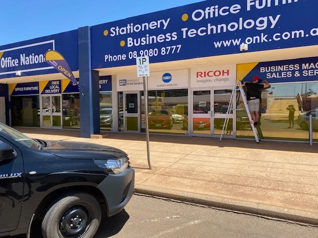 A car is parked in front of an office nation store