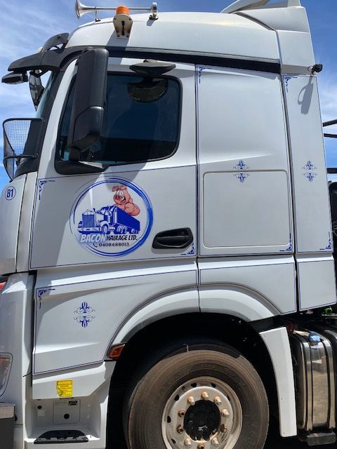A white truck with a blue logo on the side of it