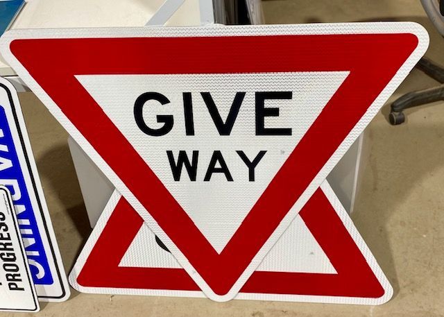 A red and white sign that says give way