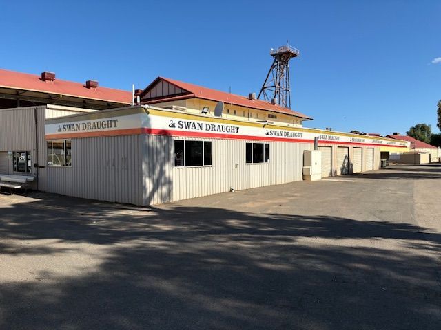 Long, low, white and tan building with signage: 