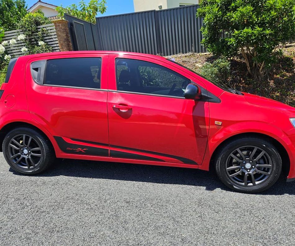 A Red Car is Parked on the Side of the Road — PJ Tinting In Port Macquarie, NSW