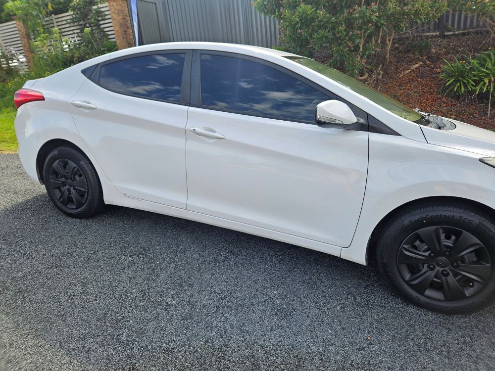 A White Car is Parked on the Side of the Road — PJ Tinting In Bonny Hills, NSW