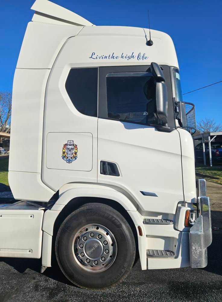 White semi-truck cab with a logo and the words