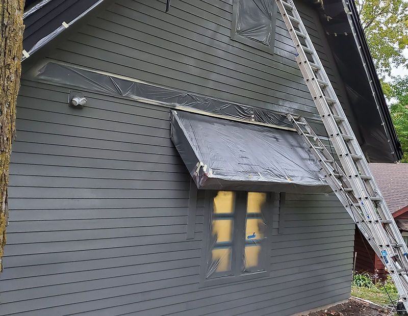 A ladder is sitting on the side of a house.