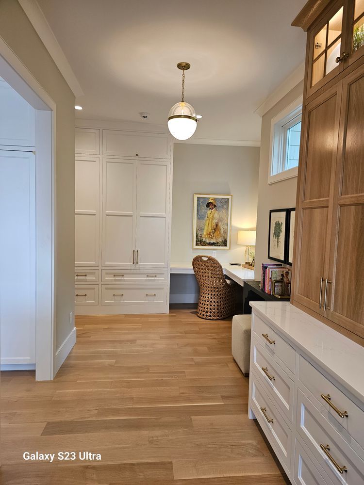 A hallway with a desk and chair in a home office.