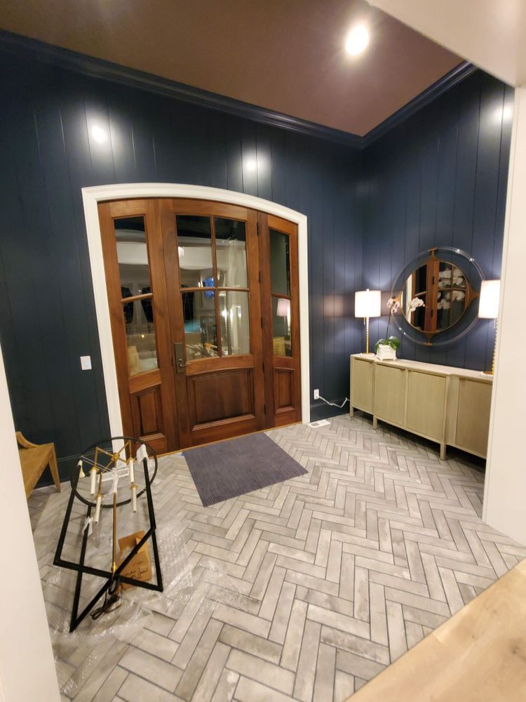 A living room with a wooden door and a herringbone floor.