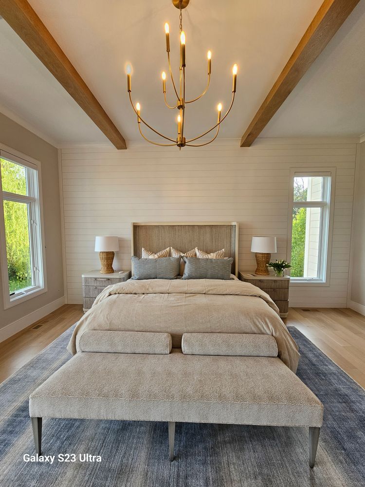 A bedroom with a bed and a chandelier hanging from the ceiling.