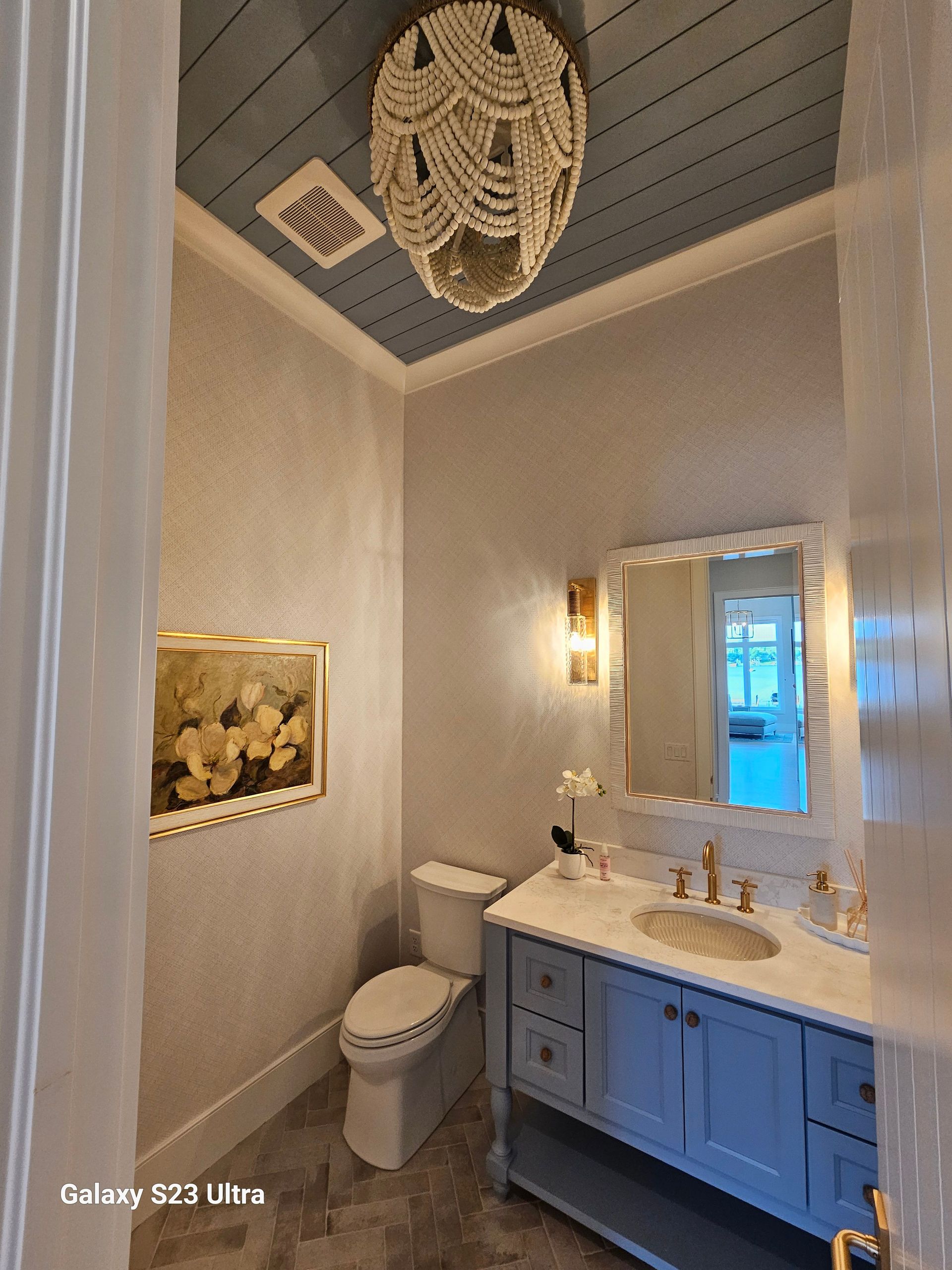 A bathroom with a toilet , sink and mirror.