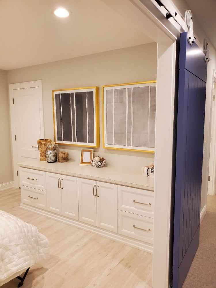 A room with white cabinets and a blue sliding barn door.