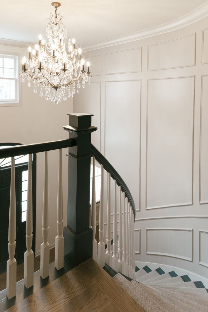 A staircase with a chandelier hanging from the ceiling