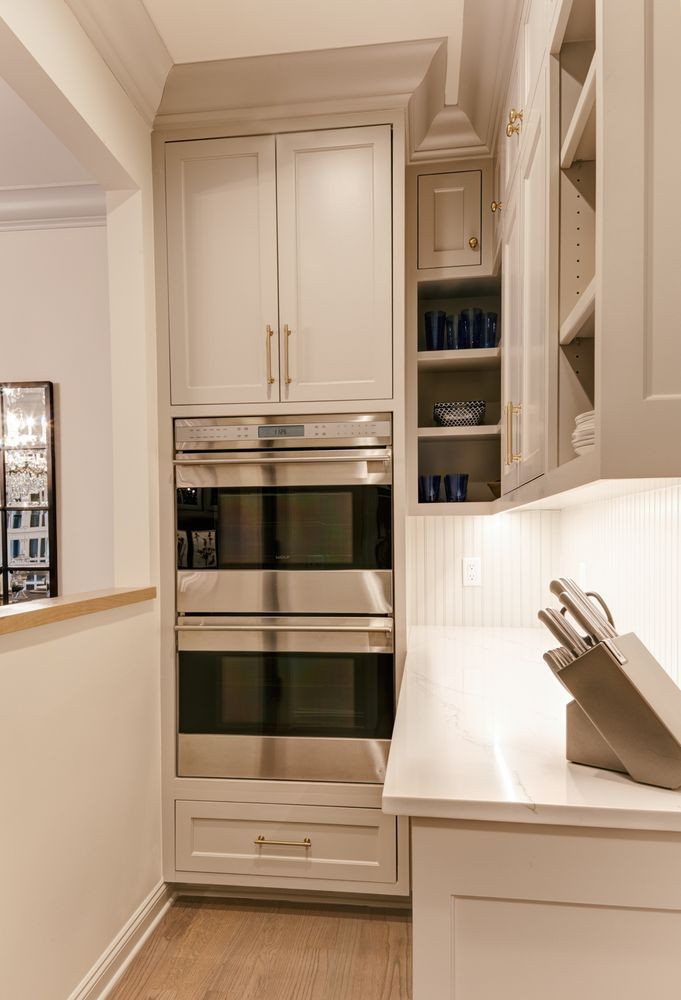 A kitchen with stainless steel appliances and white cabinets.
