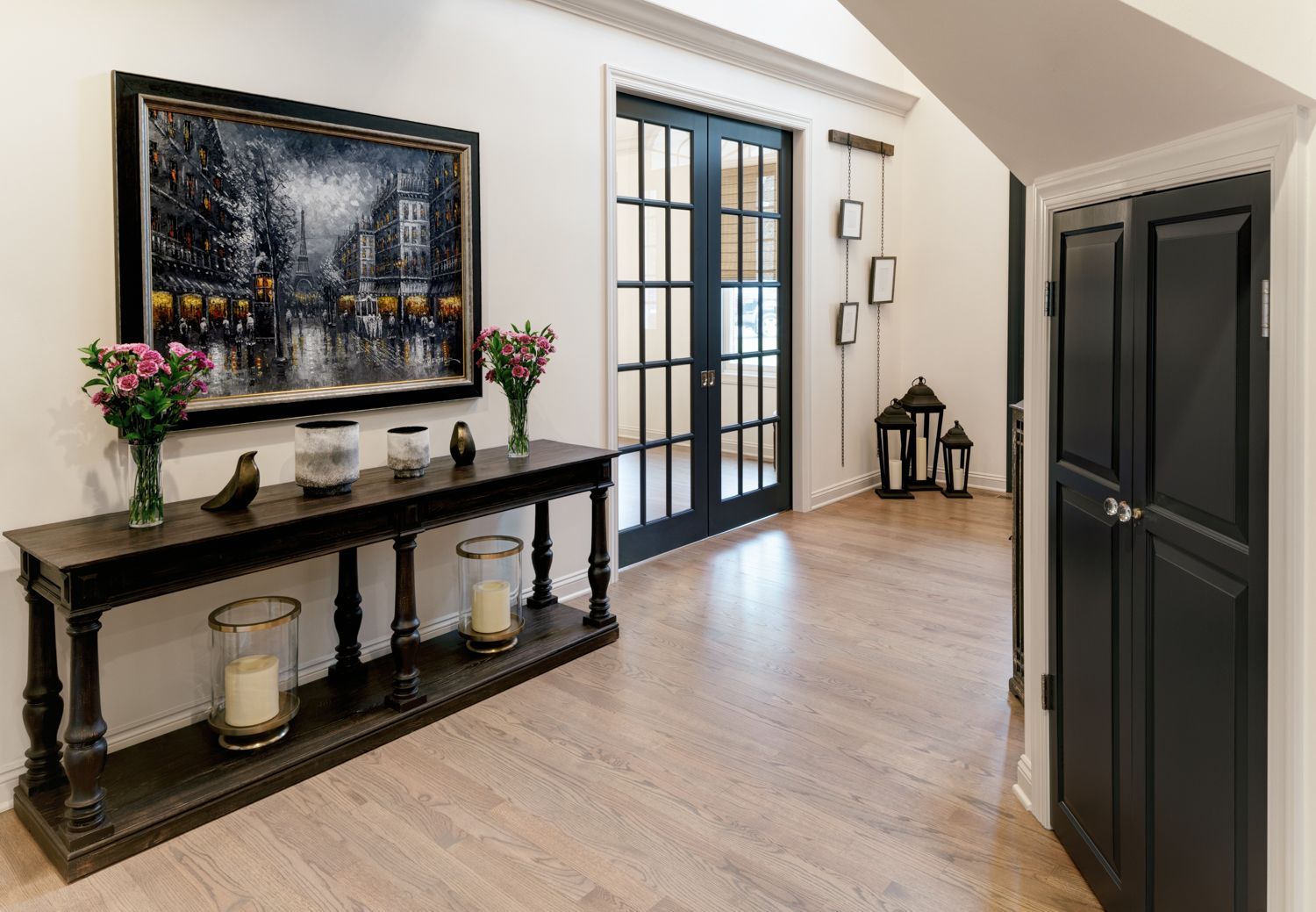 A hallway with a table and a painting on the wall.